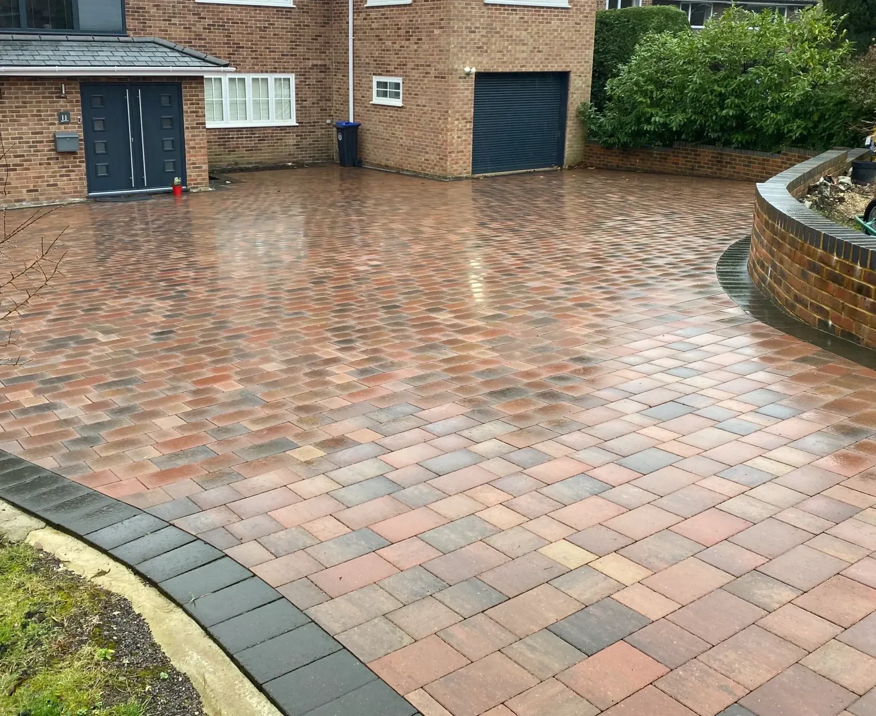 Curved brindle block paving driveway laid in herringbone in front of a house