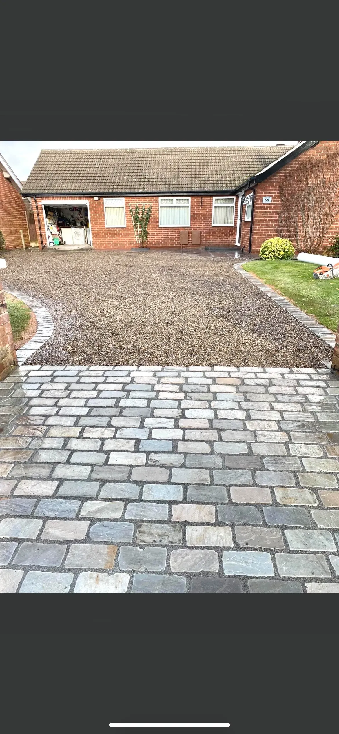 Granite sett driveway laid in an arced pattern outside a bungalow