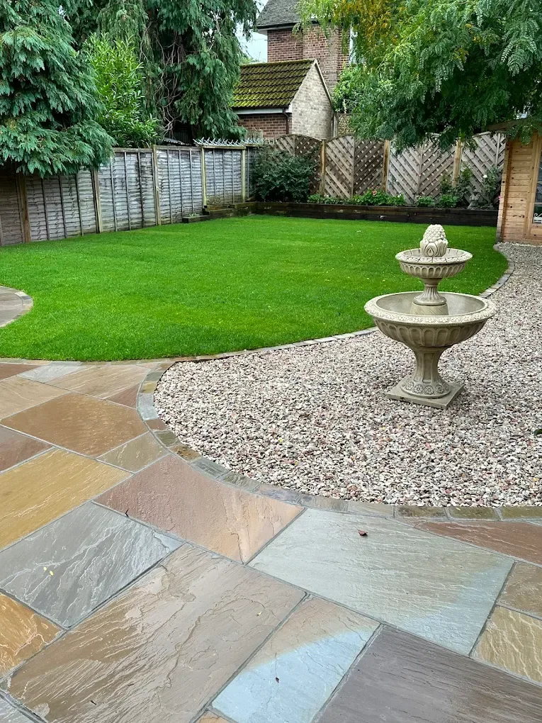 Indian sandstone patio beside a freshly laid lawn