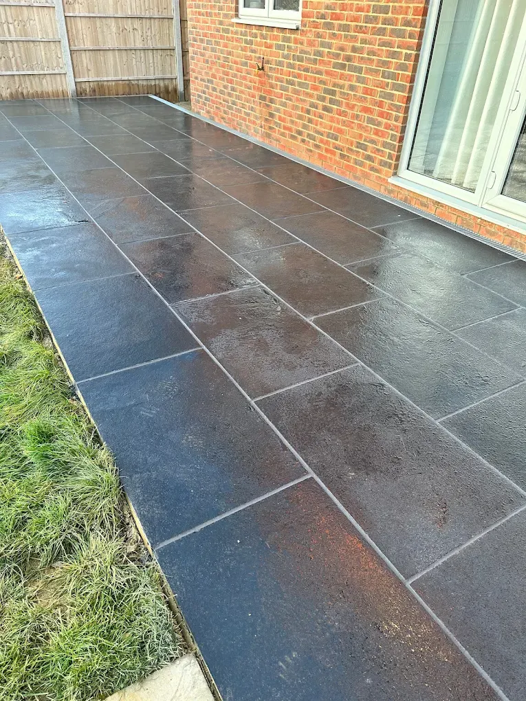 Dark riven slate paving path running along the side of a house